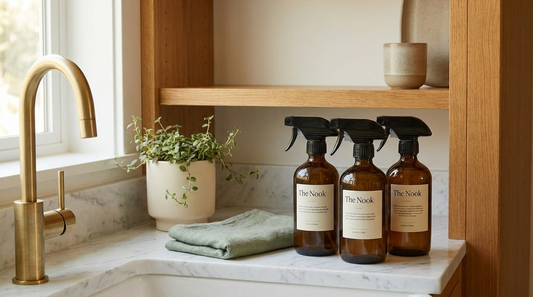 Natural non-toxic cleaning products in refillable amber glass bottles on a kitchen counter