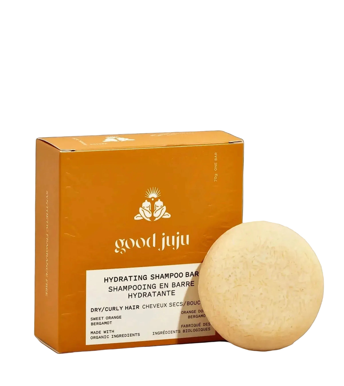 A round, pale yellow shampoo bar next to its orange packaging box, labeled 'good juju' and 'Hydrating Shampoo Bar' on a solid pale pink background.